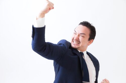 新規クライアントとの商談成功で拳を上げて叫ぶドイツ人ハーフ男性